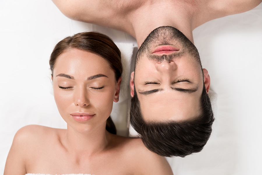top view of beautiful couple with closed eyes lying together in Reborn Island